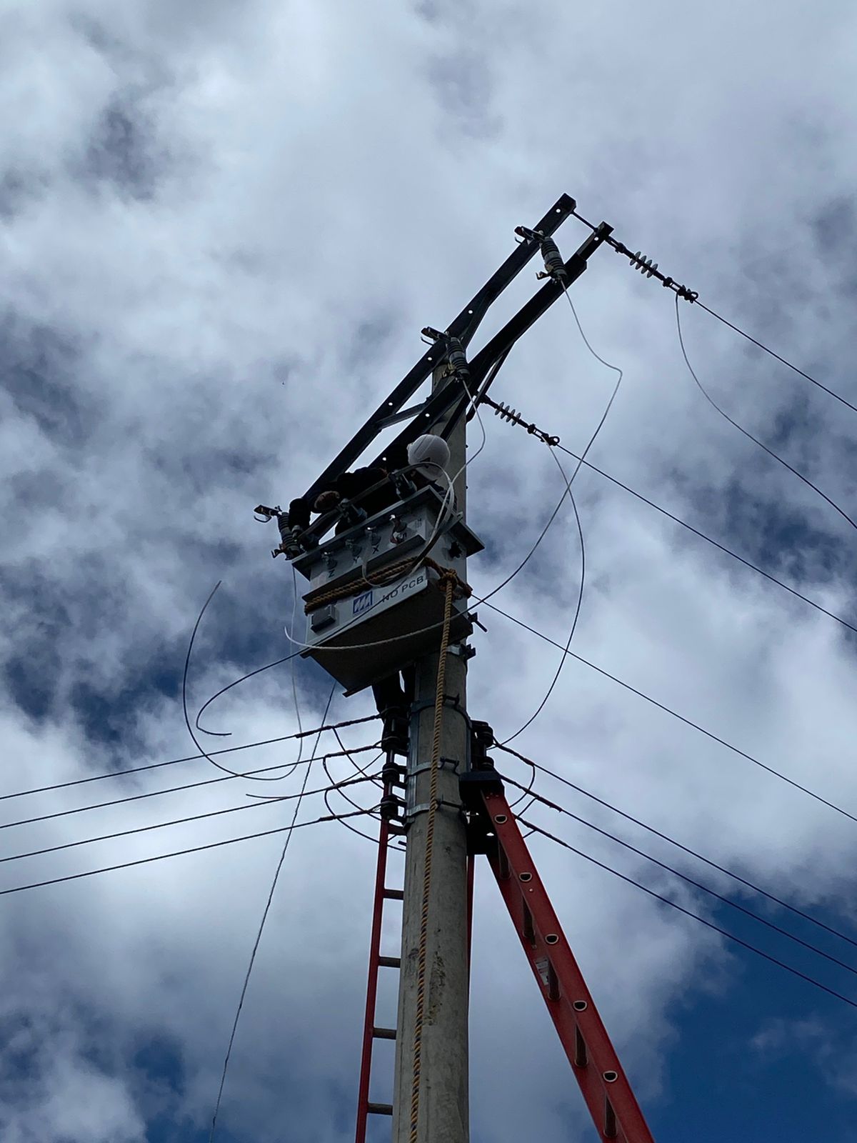 Técnico realizando mantenimiento en torre de distribución eléctrica